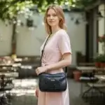 Sac à main de fabrication artisanale en cuir écologique noir et empiècement effet python. Porté par mannequin ia.