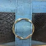 Sac à main femme en liège végétalien. Couleur bleu et empiècement noir motif reptile. Format pochette compacte. Porté bandoulière. Boucle décorative.