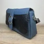 Sac à main femme en liège végétalien. Couleur bleu et empiècement noir motif reptile. Format pochette compacte. Porté bandoulière. Profil du sac.