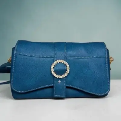 Sac à main femme en cuir écologique. Couleur bleu canard. Format pochette compacte. Porté bandoulière.