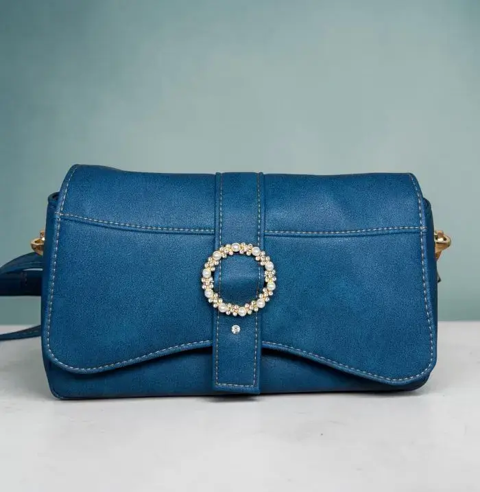 Sac à main femme en cuir écologique. Couleur bleu canard. Format pochette compacte. Porté bandoulière.