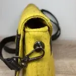 Sac à main femme en liège végétalien. Couleur jaune et empiècement noir motif grainé brillant Format pochette compacte. Porté bandoulière. Attaches des anses.