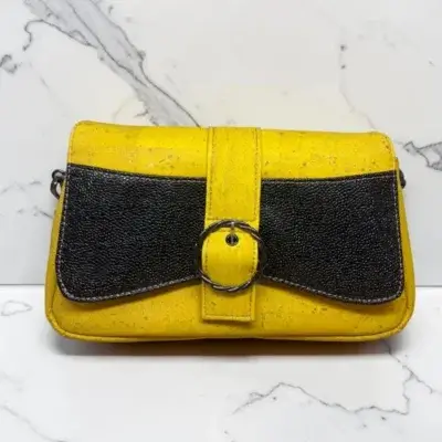 Sac à main femme en liège végétalien. Couleur jaune et empiècement noir motif grainé brillant Format pochette compacte. Porté bandoulière.