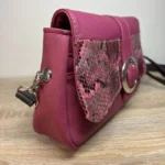 Sac à main femme en cuir écologique. Couleur vert. Format pochette compacte. Porté bandoulière. Empiècement effet peau de serpent. Attaches de la bandoulière.