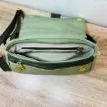 Sac à main femme en cuir écologique. Couleur duo de vert. Format pochette compacte. Porté bandoulière. Intérieur du sac.