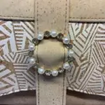 Sac à main femme en liège végétalien. Couleur beige et motifs géométriques. Format pochette compacte. Porté bandoulière. Boucle décorative.