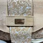 Sac à main de fabrication artisanale en liège végétal beige naturel et imprimé arabesque blanc. Modèle avec rabat et bandoulière réglable. face avant, détails du liège.