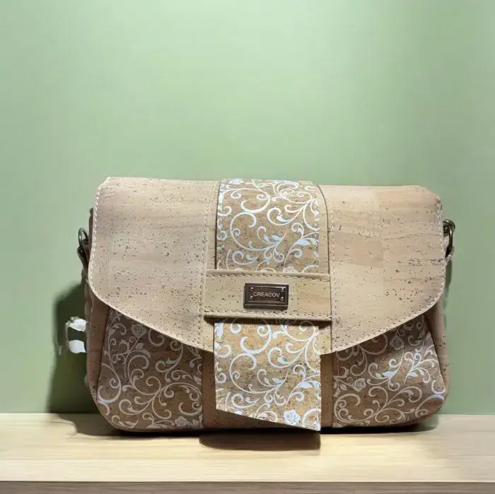Sac à main de fabrication artisanale en liège végétal beige naturel et imprimé arabesque blanc. Modèle avec rabat et bandoulière réglable. face avant.