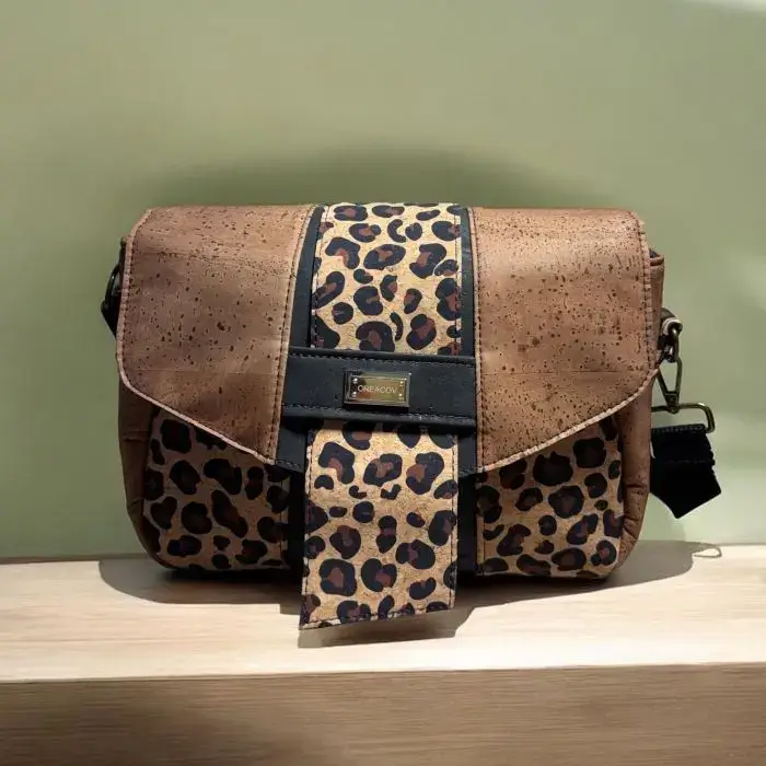 Sac à main de fabrication artisanale en liège végétal marron; noir, imprimé léopard. Modèle avec rabat et bandoulière réglable.