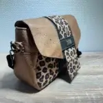 Sac à main de fabrication artisanale en liège végétal marron; noir, imprimé léopard. Modèle avec rabat et bandoulière réglable.