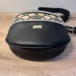 Sac banane en cuir synthétique noir effet satiné. Trois poches zippées. Intérieure toile imperméable. Bandoulière réglable. Vue dessous.