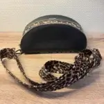 Sac banane en cuir synthétique noir effet satiné. Trois poches zippées. Intérieure toile imperméable. Bandoulière réglable. Vue dessus.