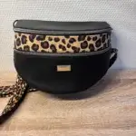 Sac banane en cuir synthétique noir effet satiné. Trois poches zippées. Intérieure toile imperméable. Bandoulière réglable. Vue avant.