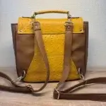 Sac à dos en cuir écologique marron clair et jaune piqué marron. Arrière du sac . Détails des bretelles réglables.