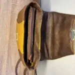 Sac à dos en cuir écologique marron clair et jaune piqué marron. Dessus du sac . Fermeture zippèe.