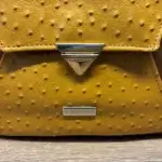 Sac à dos en cuir écologique marron clair et jaune piqué marron. Détails fermoir cartable et sur aspect cuir écologique