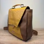 Sac à dos en cuir écologique marron clair et jaune piqué marron. Vue de profil.