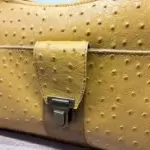 sac à main fait main . Se porte en bandoulière. Similicuir jaune piqué et camel. Détail poche avant attache cartable