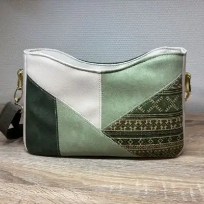 Sac à main de fabrication artisanale en cuir écologique vert et beige, empiècement effet mosaïque. interface structuré et géométrique. Avant du sac.